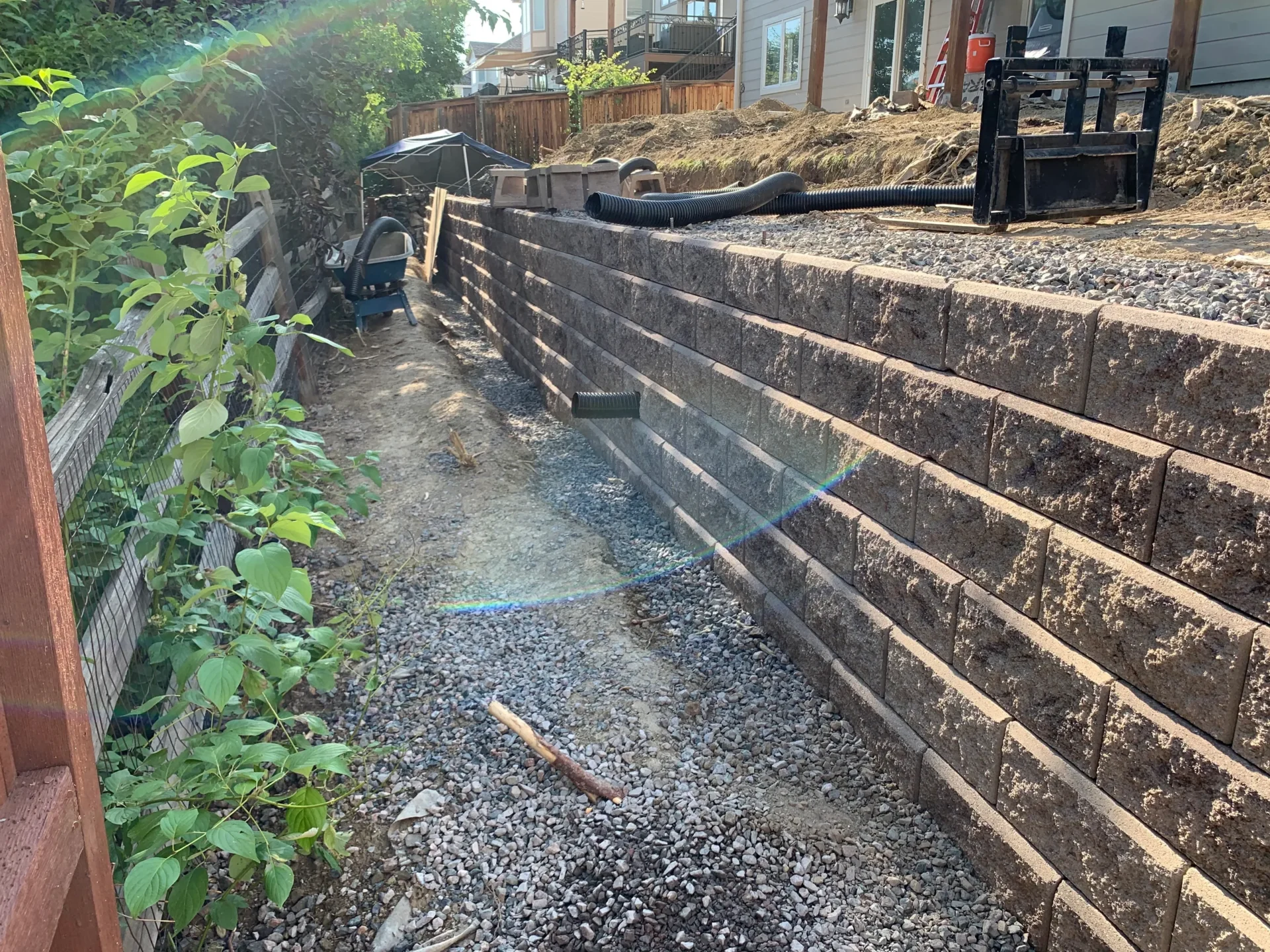 A large stone wall with steps and plants growing.