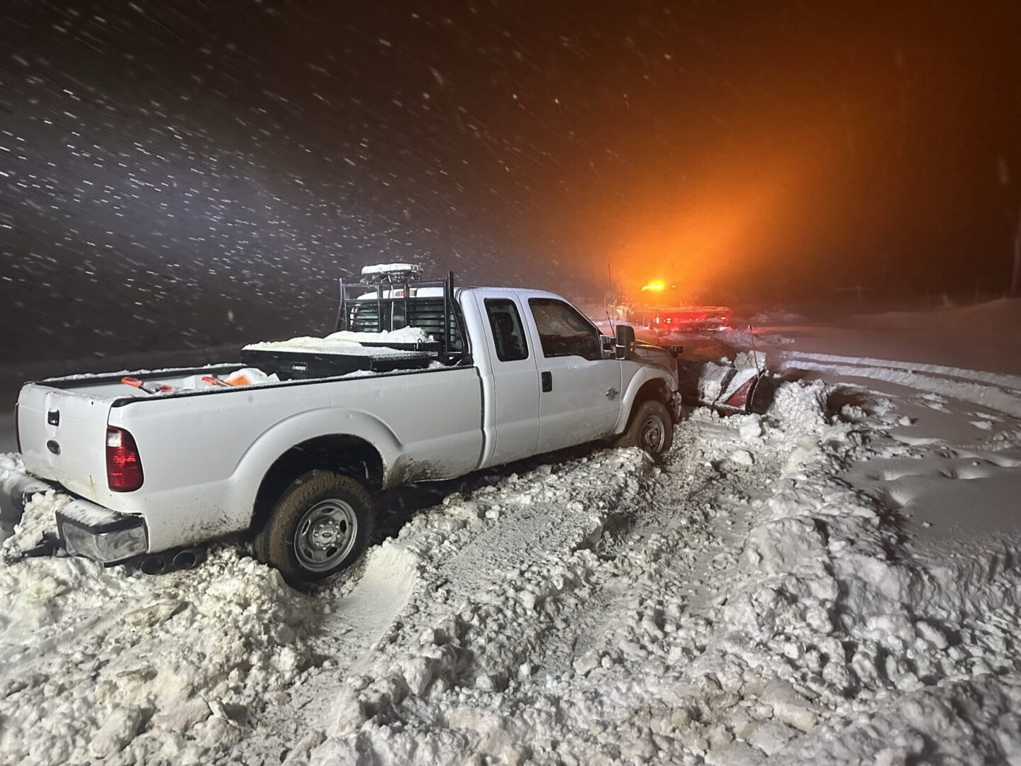 A white truck is parked in the snow